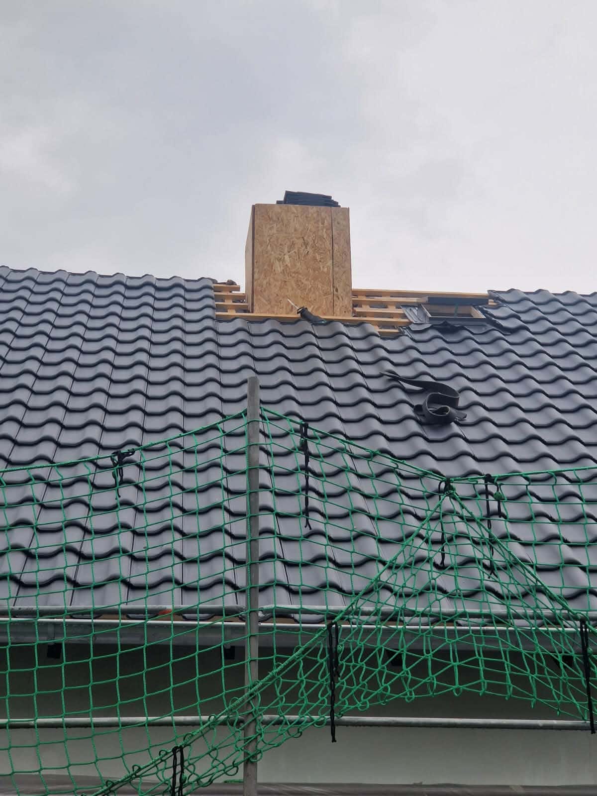 Neu eingedecktes Ziegeldach mit Schornstein und Dachfenster